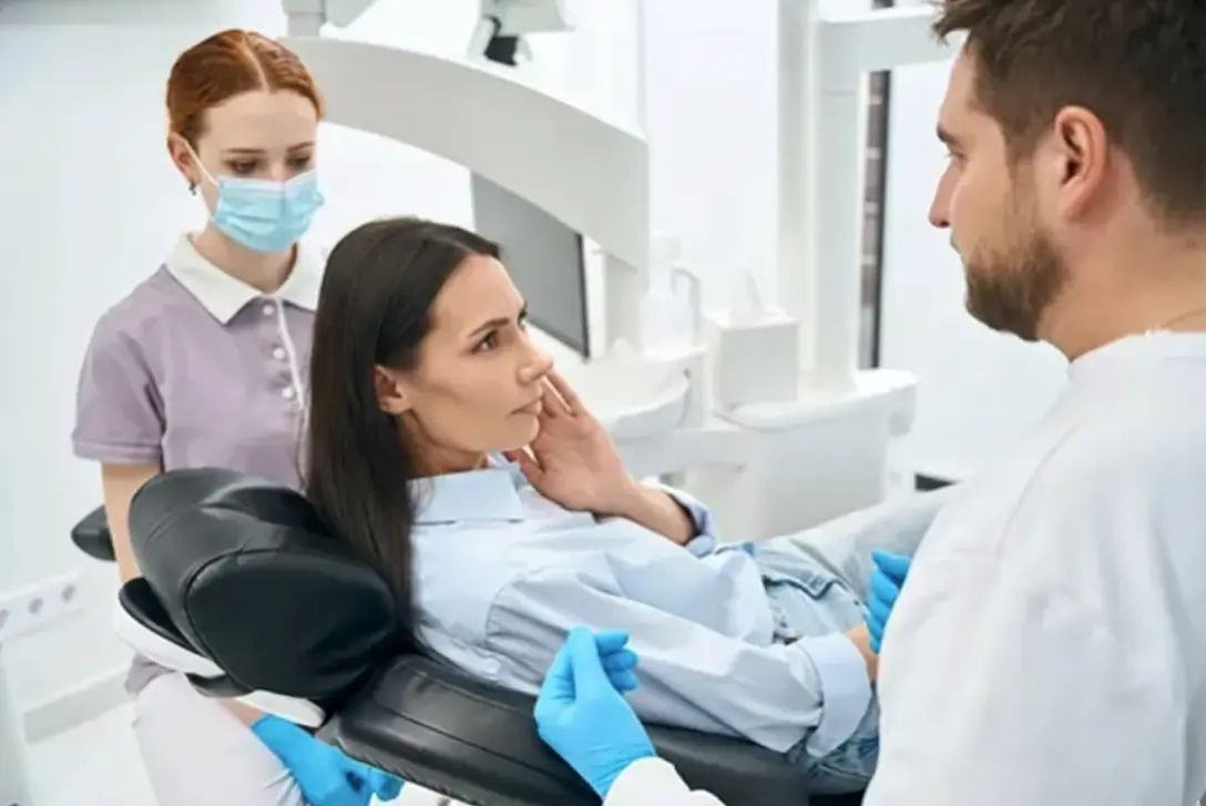 Dentista explicando um tratamento para paciente em ambiente claro, moderno e calmo