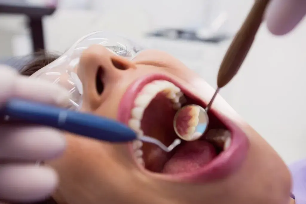 Profissional realizando tratamento periodontal em paciente