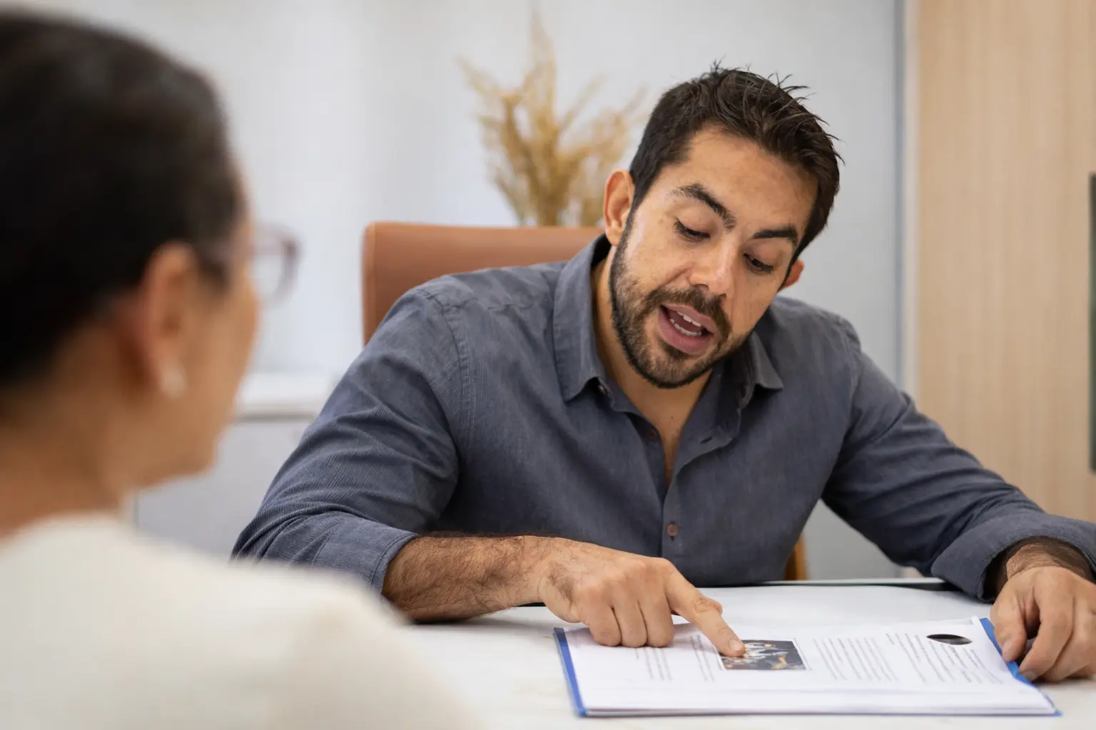 Dentista explicando um tratamento para paciente em ambiente claro, moderno e calmo