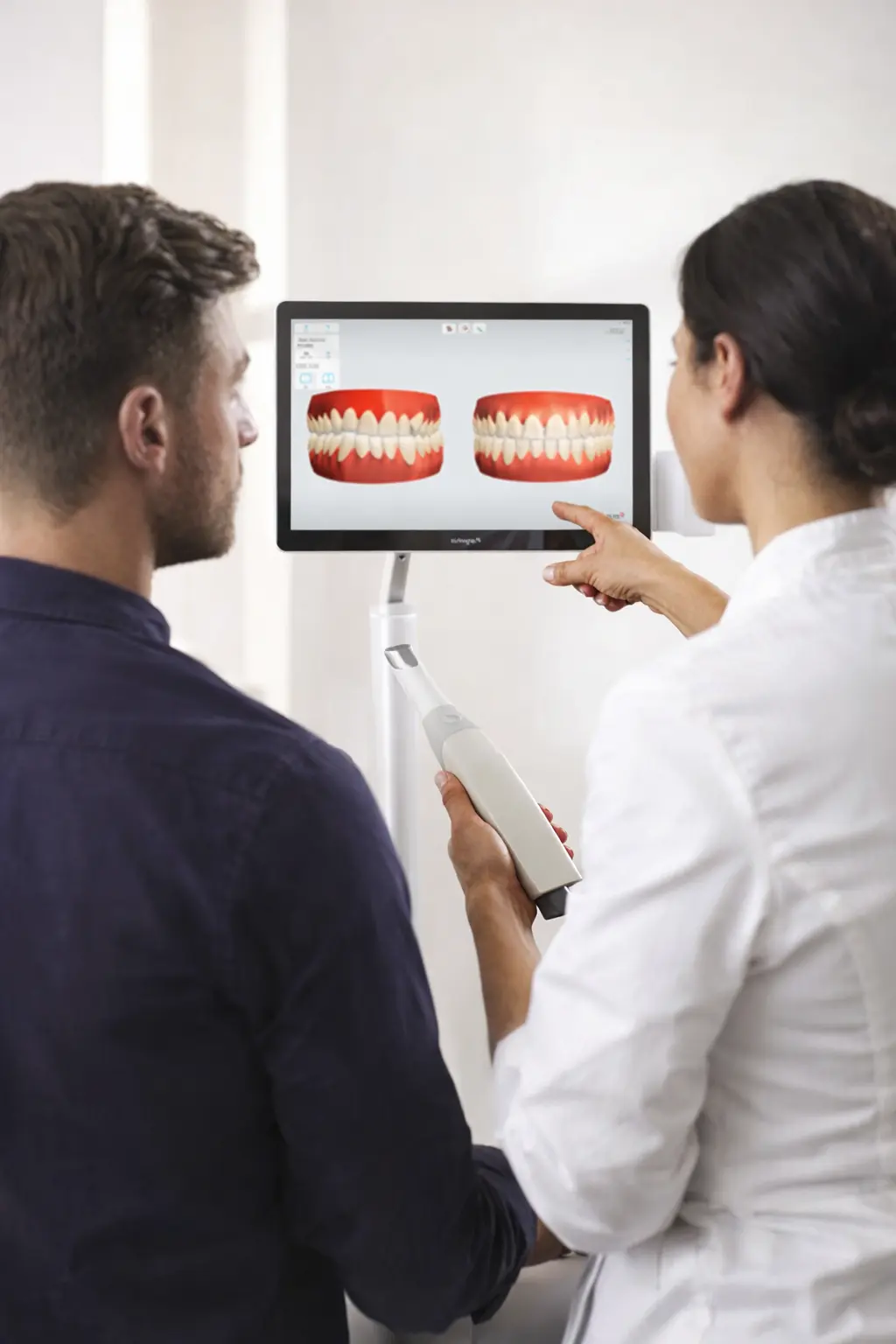 Dentista explicando um tratamento para paciente em ambiente claro, moderno e calmo